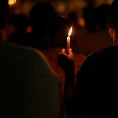 Person holding a candlelight in a dark night, Myanmar.