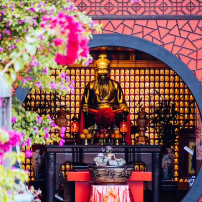 A Buddha at Weitian Temple 桃園威天宮, surrounded by flowers at Taoyuan, Taiwan.