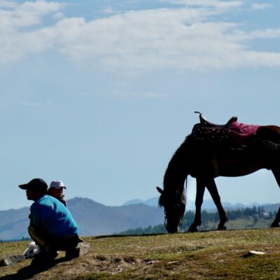 A man and child with a horse on a mountain in Xinjiang.