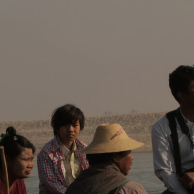 A boat carrying people, including Myint Zaw, on a river. Image used with permission from the Goldman Environmental Prize.