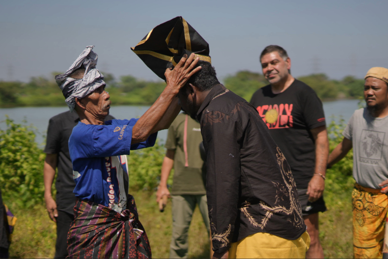 Renowned gendang musician Daeng Serang Dakko presents David Yunupiŋu with a patonro (headdress), Somba Opu, Gowa Regency, July 2025. Used with permission from Agit Pramaswara.