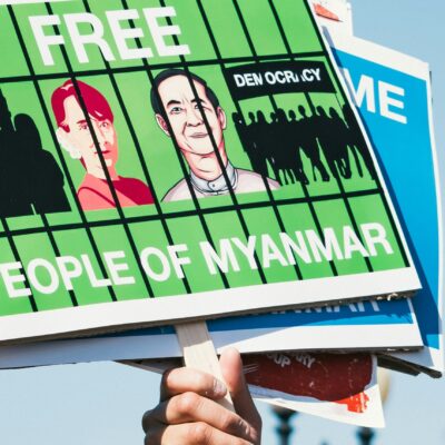 A close-up of a hand holing a banner calling for the freedom of the people of Myanmar.