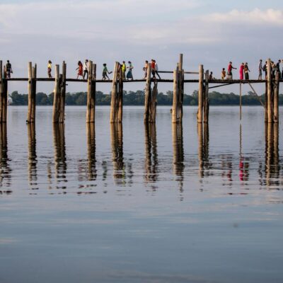 People walking over a bridge in Myanmar.