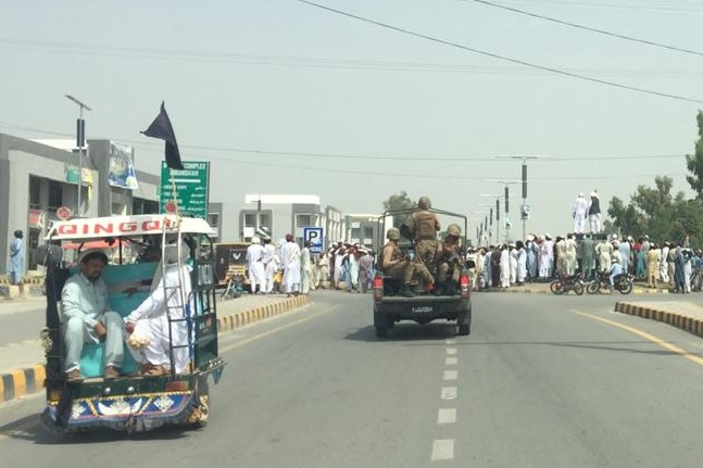 Public protest in Miranshah, North Waziristan (August 2019), with a military security escort accompanying the research team's vehicle.